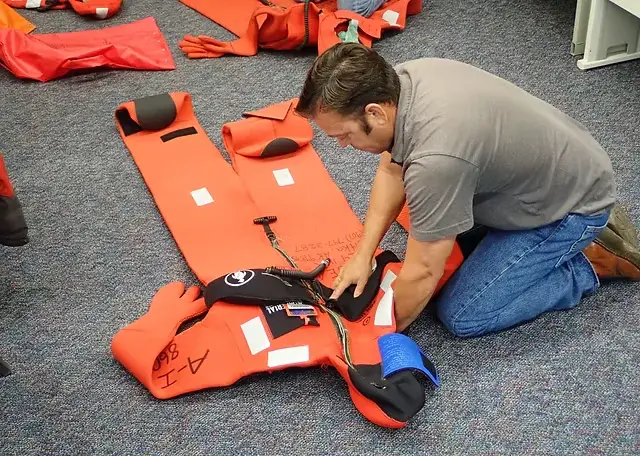 Technician inspecting life jackets and immersion suits