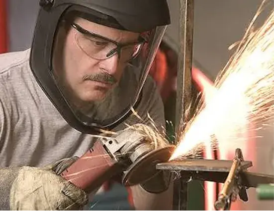 Worker wearing a welding visor and eye protection