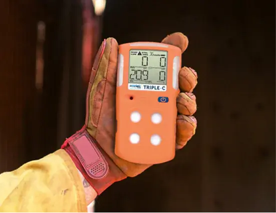 Worker holding a portable multi-gas detector